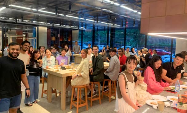 uni students of different cultural backgrounds gathered in dining area of student accommodation